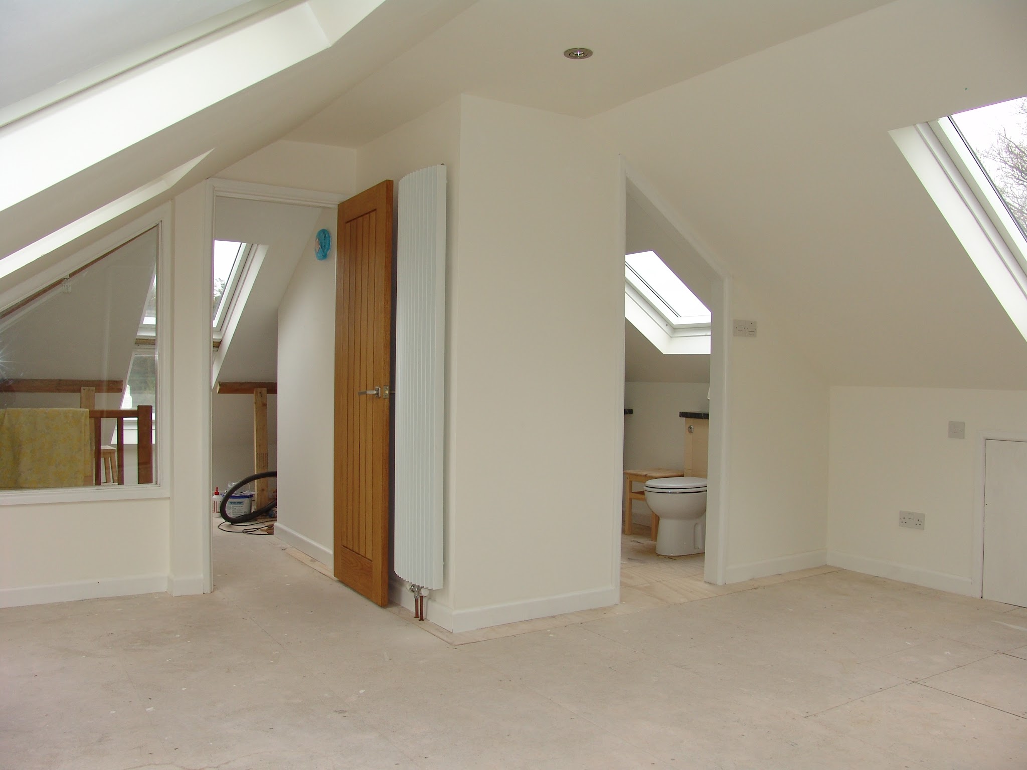 A finished loft room with roof windows, an oak door and an en-suite