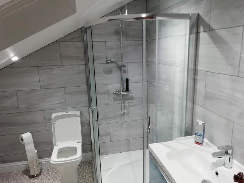 Tiled shower room under a sloping ceiling