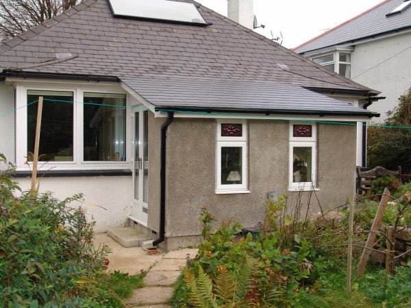 Rendered bungalow extension with a slate roof and new windows