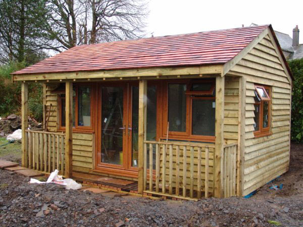 Finished timber garden room with french doors and a shingle roof