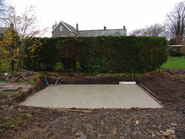 A concrete base laid out in a garden, ready for a garden room