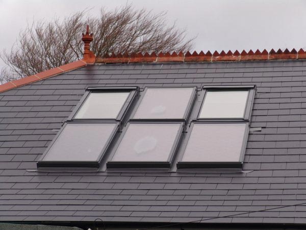 A bank of six roof windows set into a slate roof